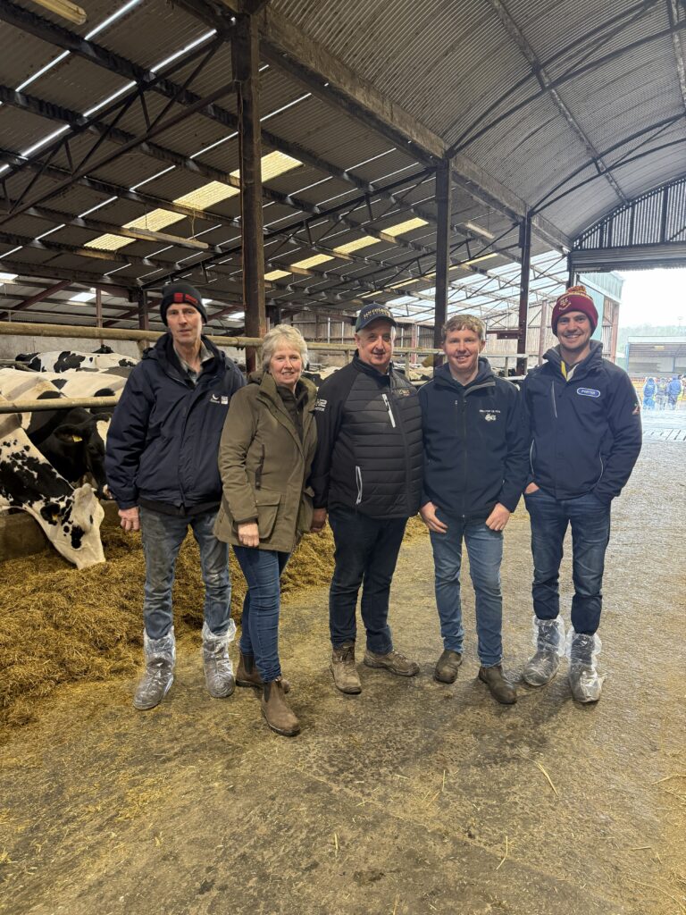 Five attendees stood in a cattle shed at the NI Open Meeting